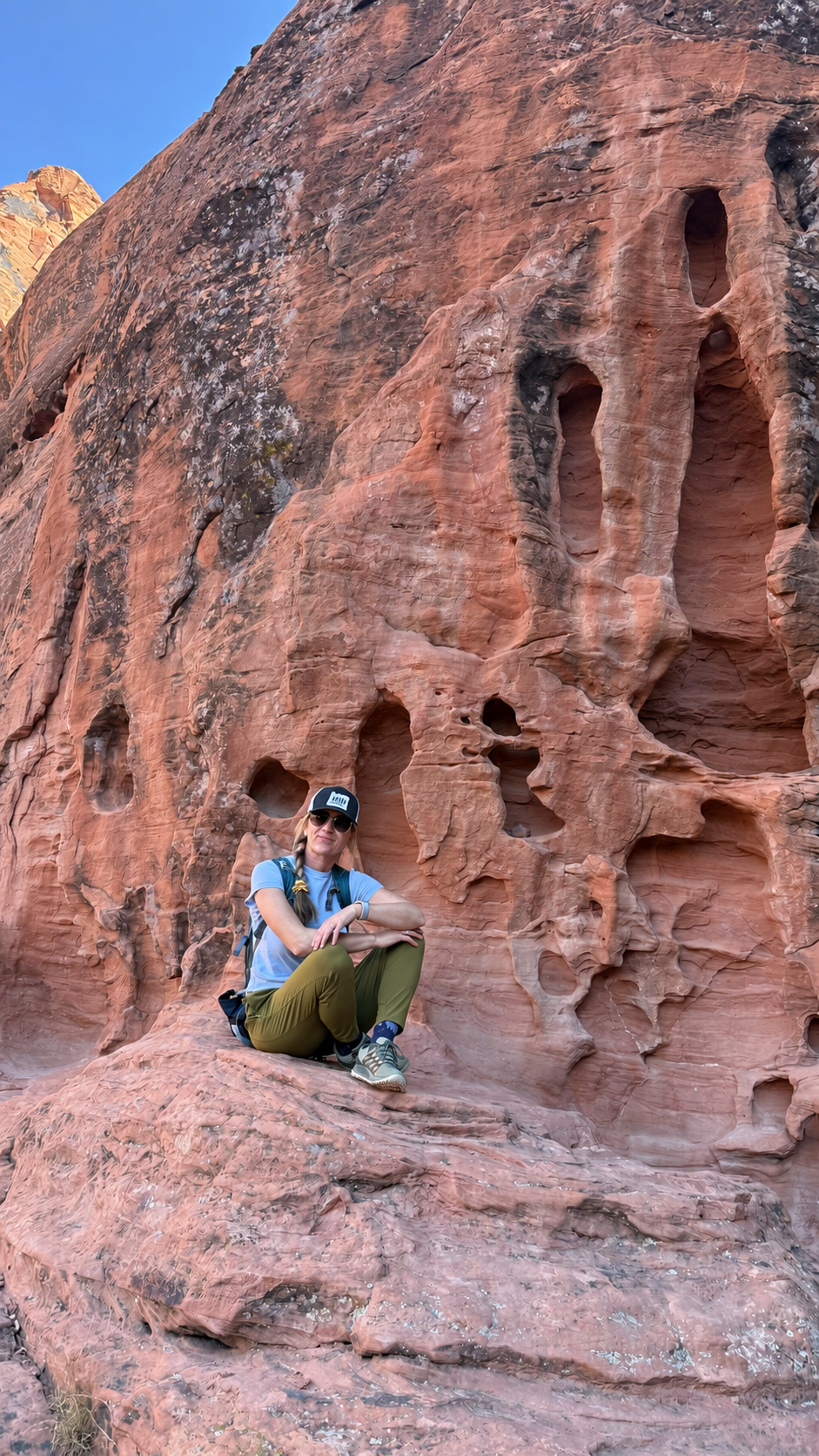 Beata sitting beside a red sandstone canyon wall