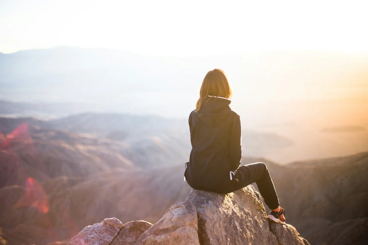 Person sitting quietly in a mountain landscape